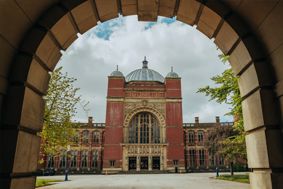 The front of the Aston Webb building framed by the arch of Old Joe