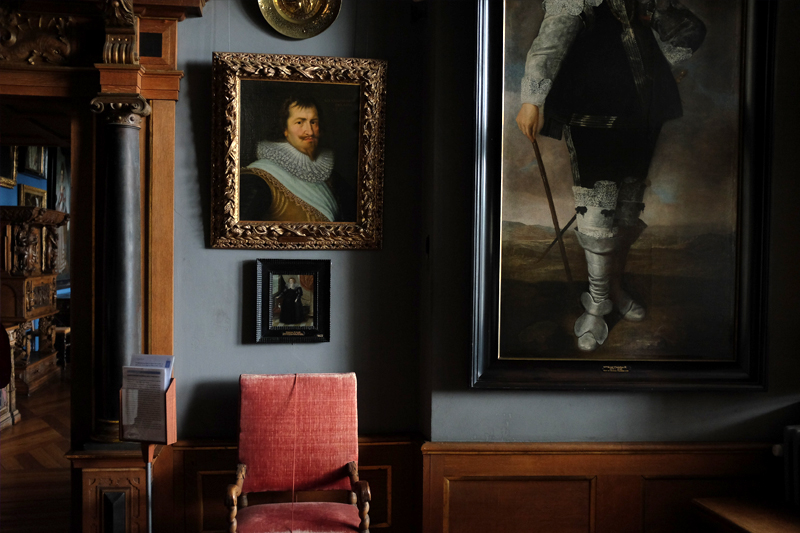 Historic portraits hanging in a dimly lit museum room