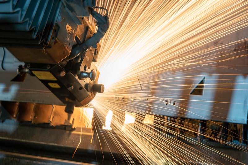 Manufacturing equipment creating a stream of yellow sparks