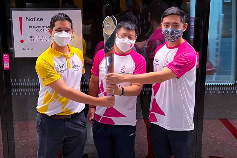 Alex Bamford, Dr Samuel Chan and Goh Kai Xiang jointly hold the Queen’s baton