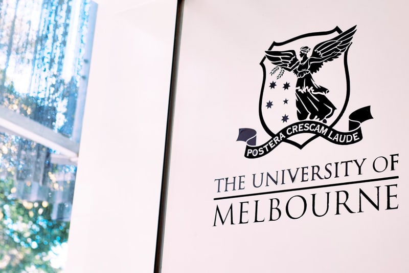 Logo for the University of Melbourne on a wall