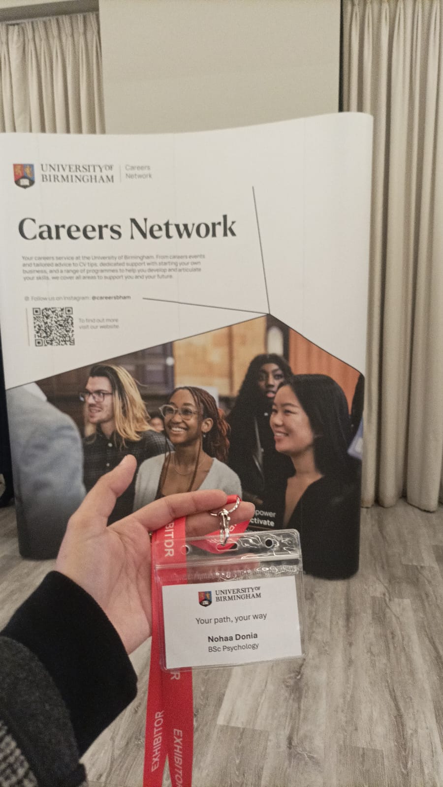Person showing their lanyard that reads 'Nohaa Donia' in front of Careers Network stand.