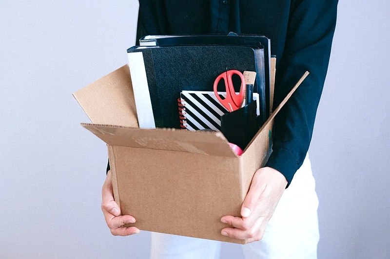 An office worker with their belongings in a box