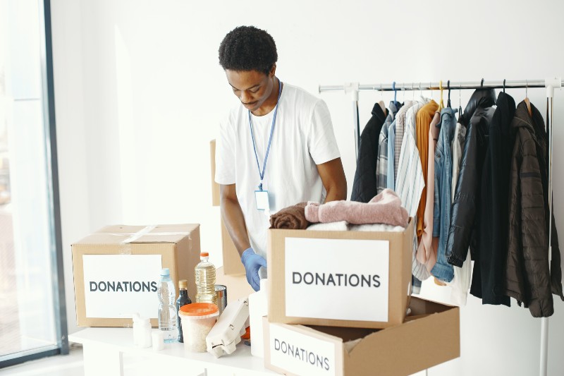 Charity worker sifting through boxes of donations in a charity shop