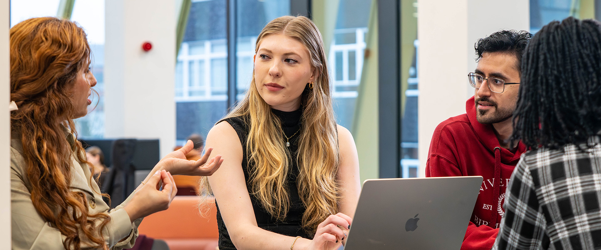 Group of students talking with laptops