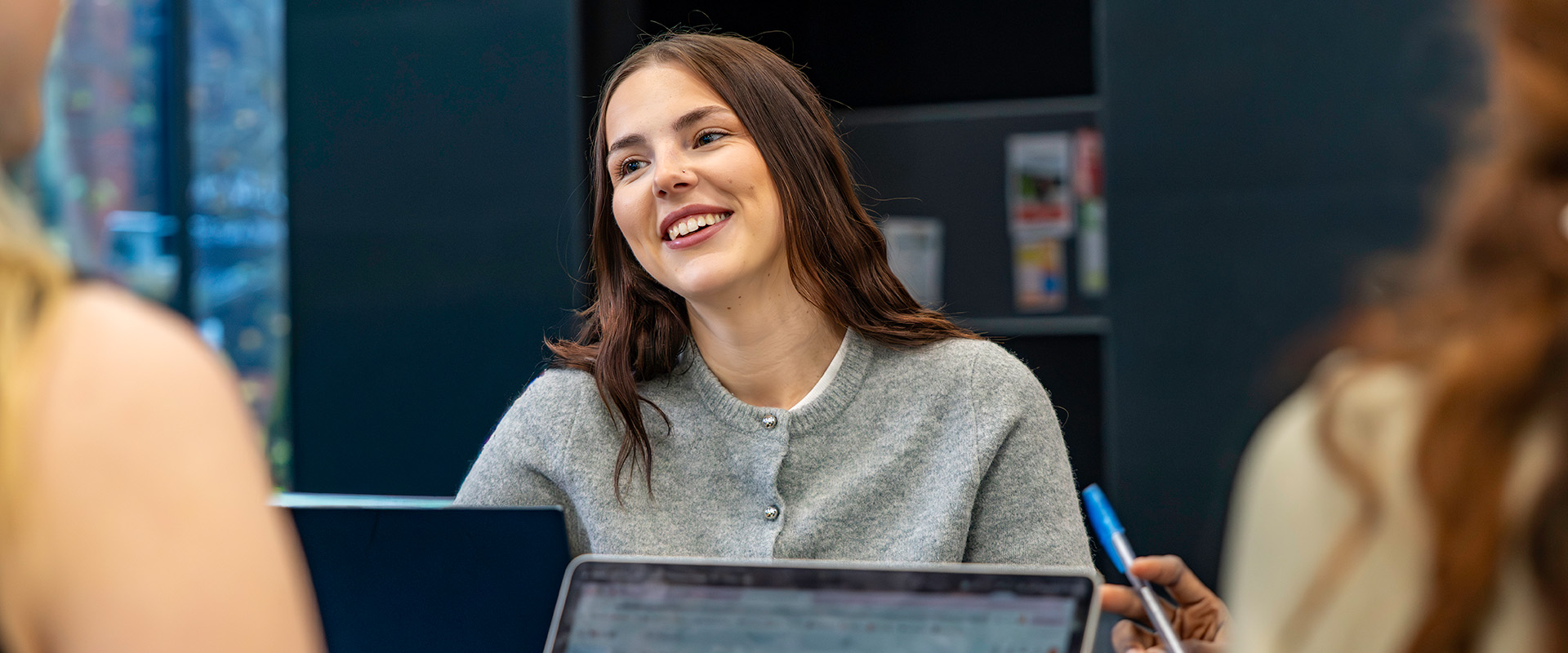 Smiling female student behind laptop