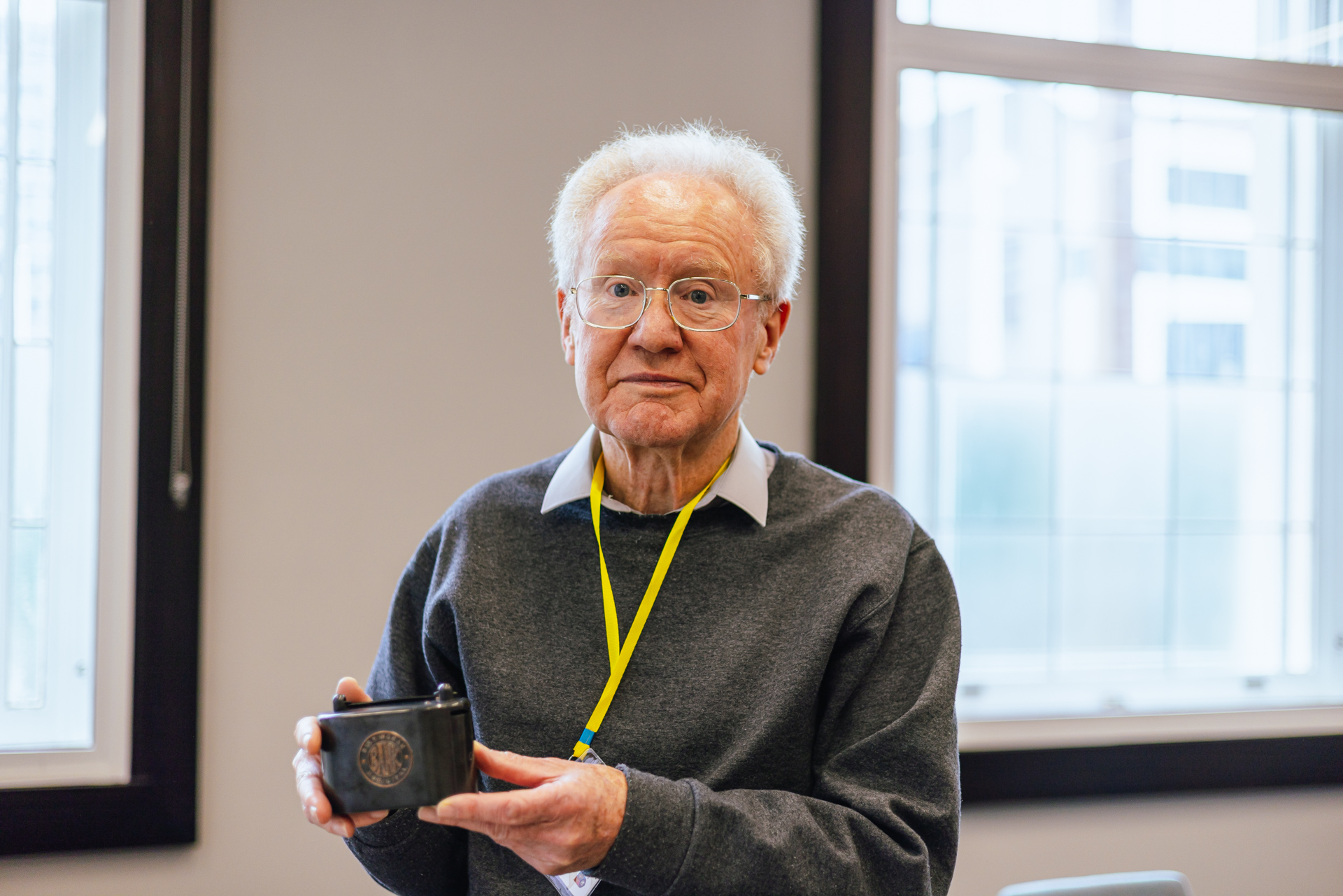 David Parkes poses for the camera holding up an old Birmingham Municipal Bank saving tin.