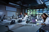 Laboratory students wearing white coats sitting in a laboratory 