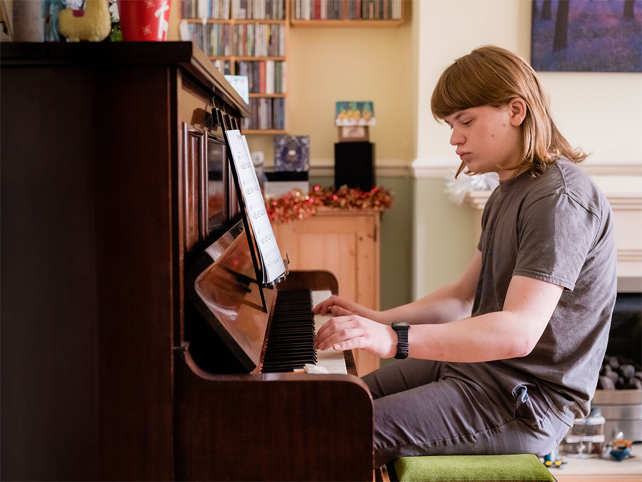 A young man plays piano