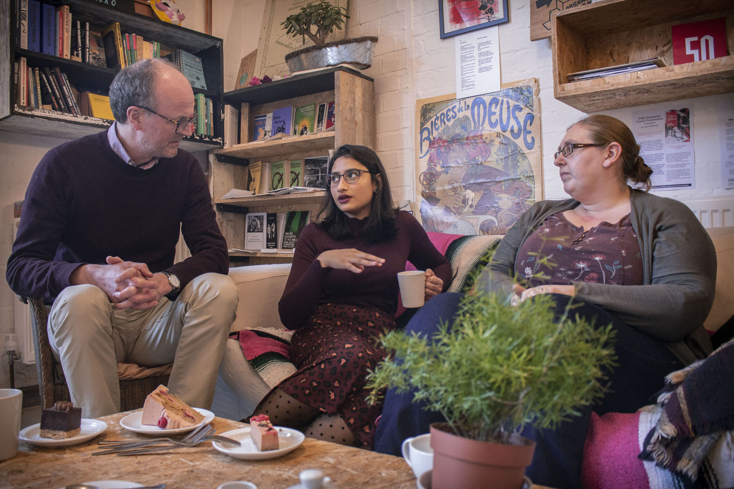 A man and two women sit and have a conversation