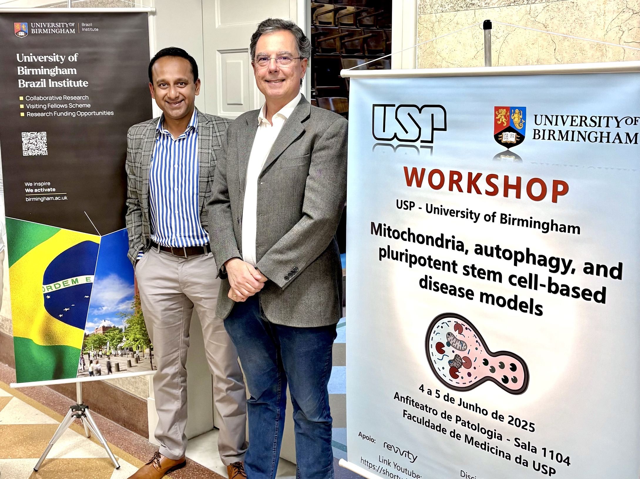 Dr Sovan Sarkar and Professor Edecio Cunha-Neto near the workshop banner