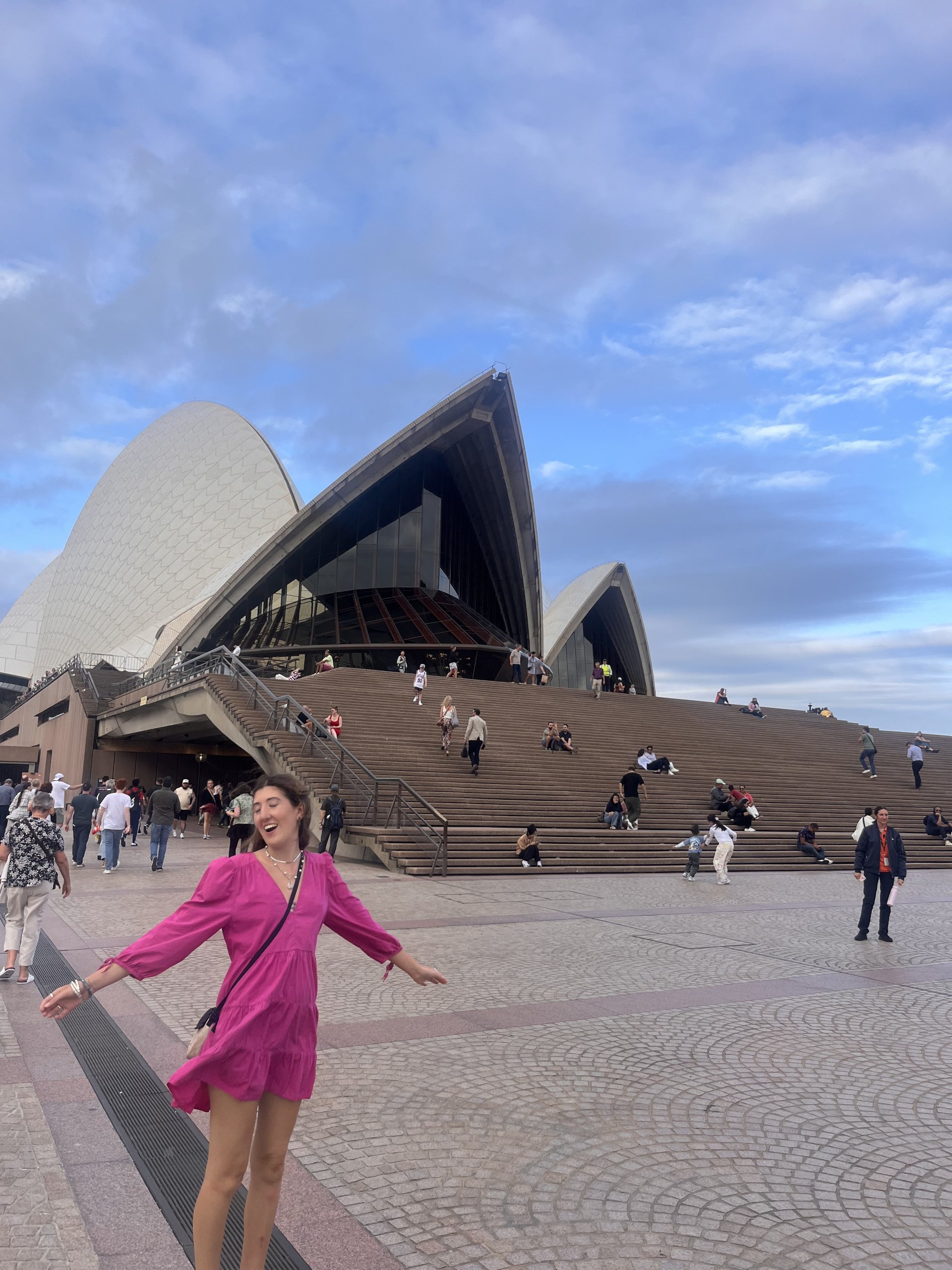 student ambassador rebecca in from of the Sydney opera house wearing a pink dress