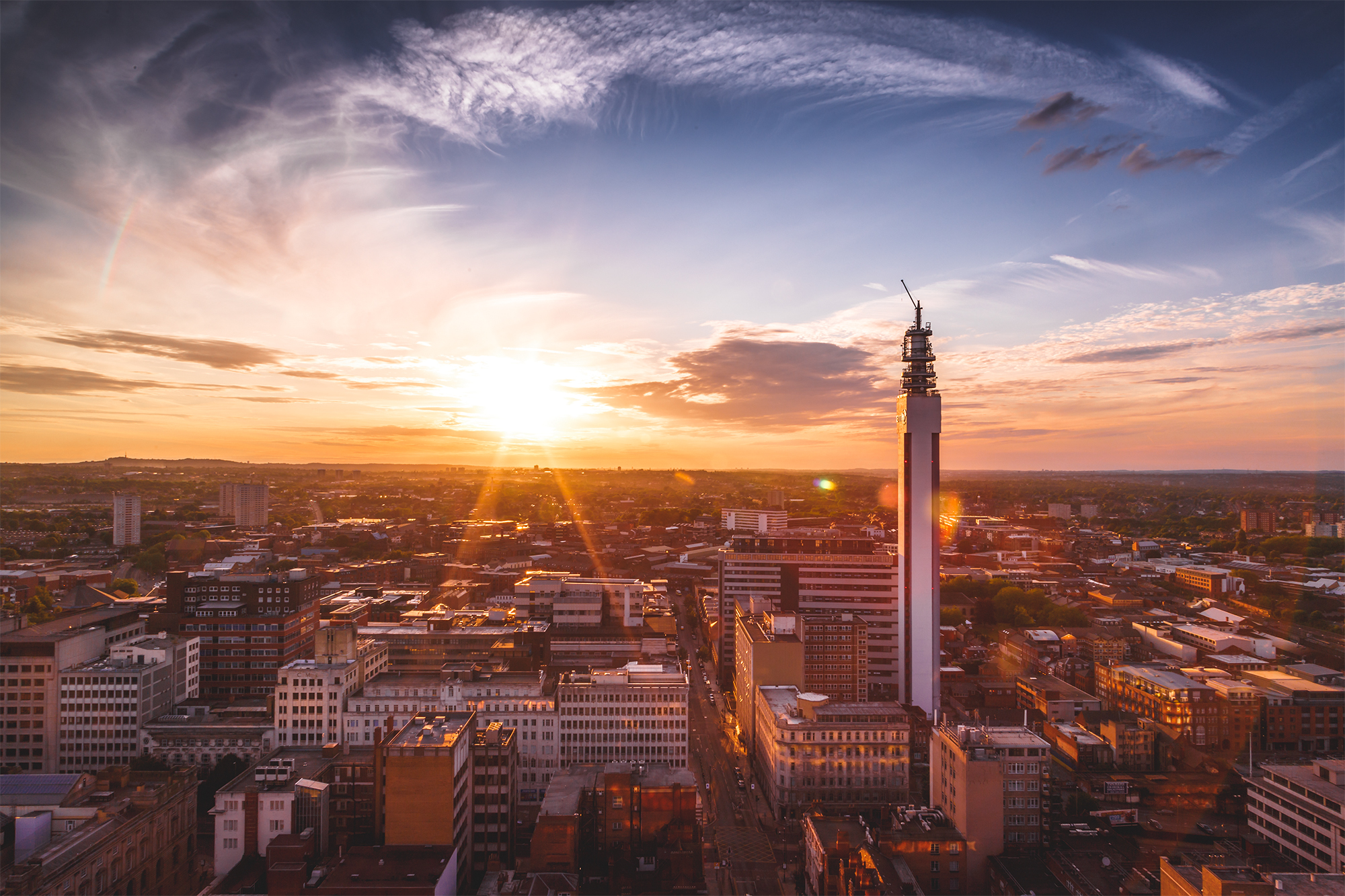 Aerial shot of Birmingham city centre with a beautiful sunset flaring on the horizon