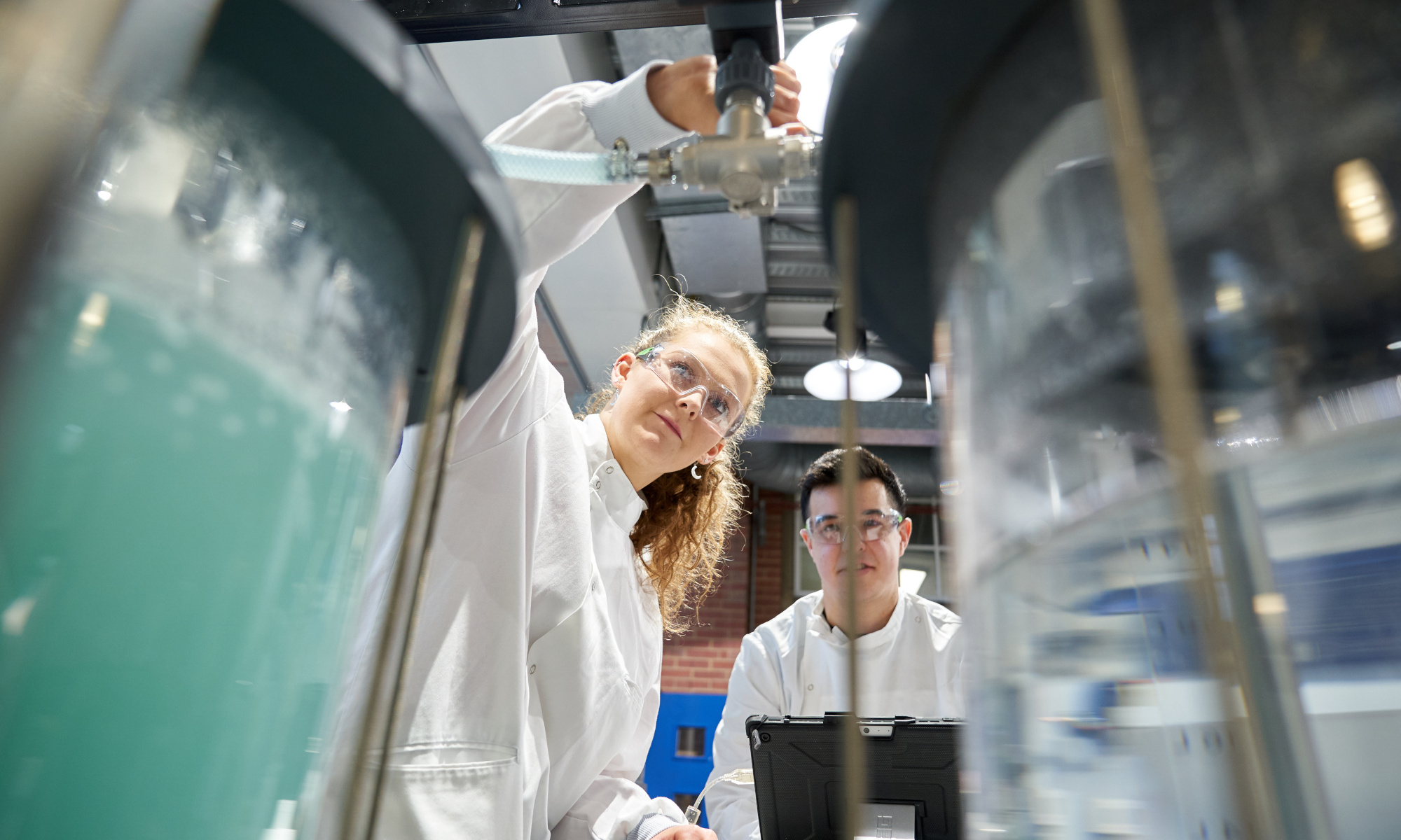 Students in a lab in between equipment which is in the foreground