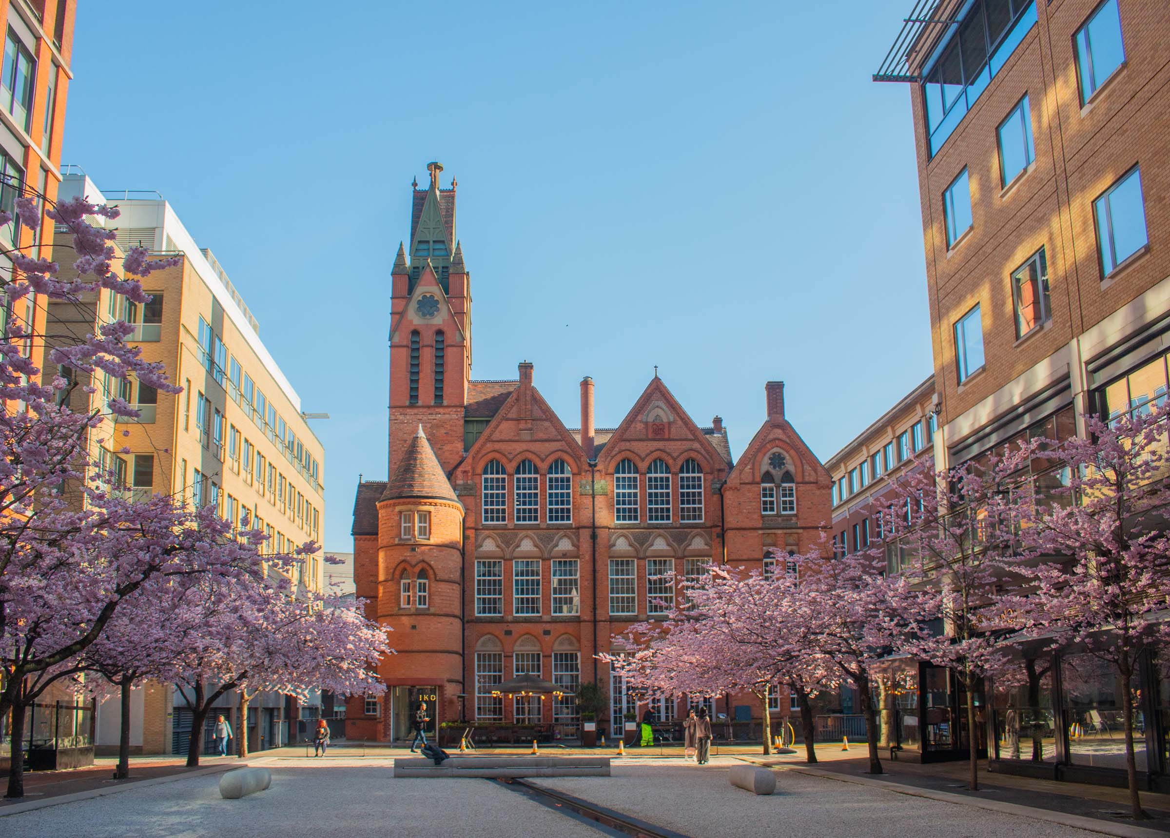 Red brick building in courtyard with blossom