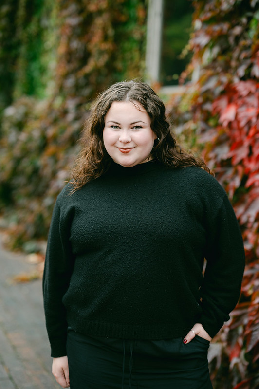 Portrait of Lorna smiling in front of the arts building 