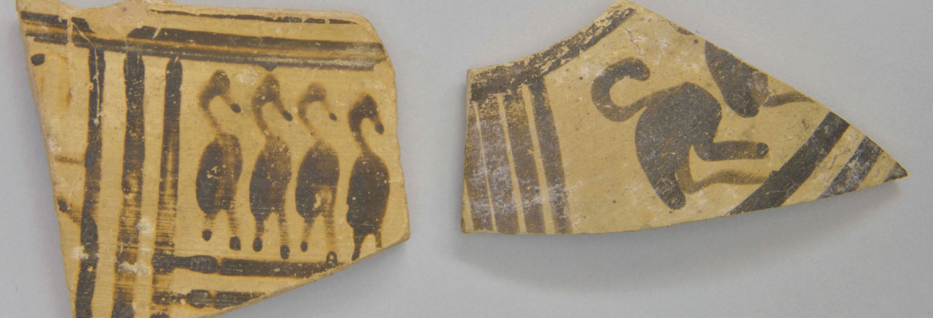 Two pottery shards featuring geometric designs of lines and birds.