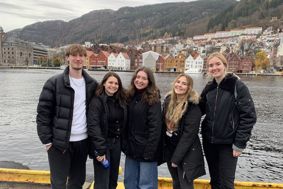 students standing in front of 'bryggen', the dock.