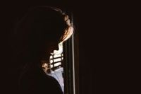 The silhouette of a woman with head slightly bowed