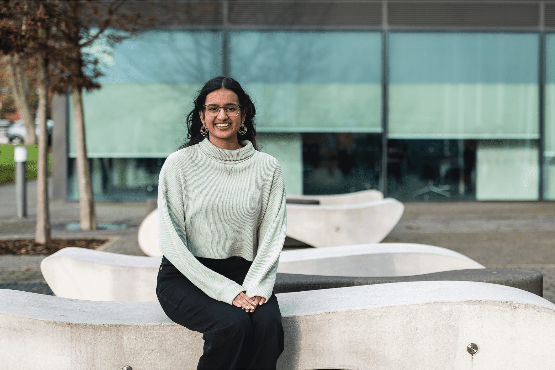 Student Anvi sits on a sculptural bench on Birmingham campus