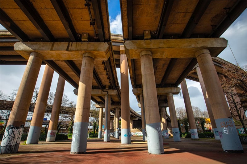 View from beneath Spaghetti Junction with large concrete pillars supporting the carriageway running overhead