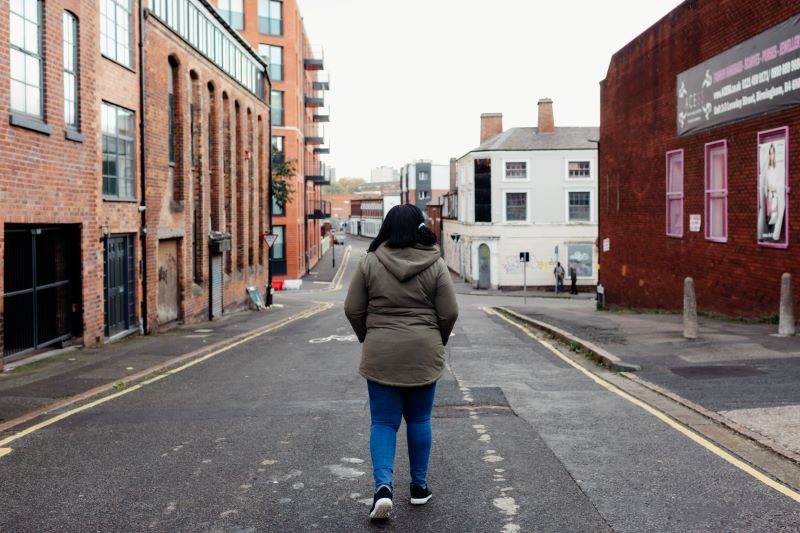 A lone woman walking down a street