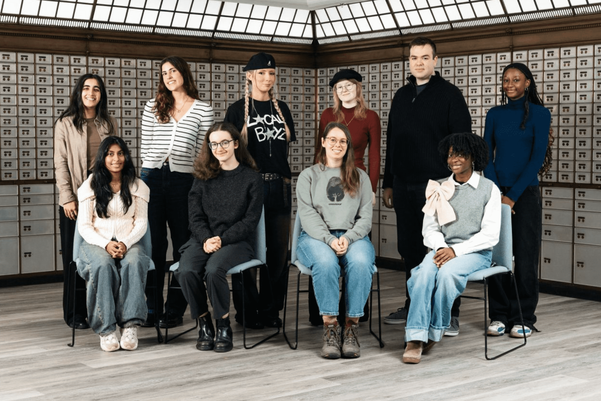 A group of students in two rows smile at the camera