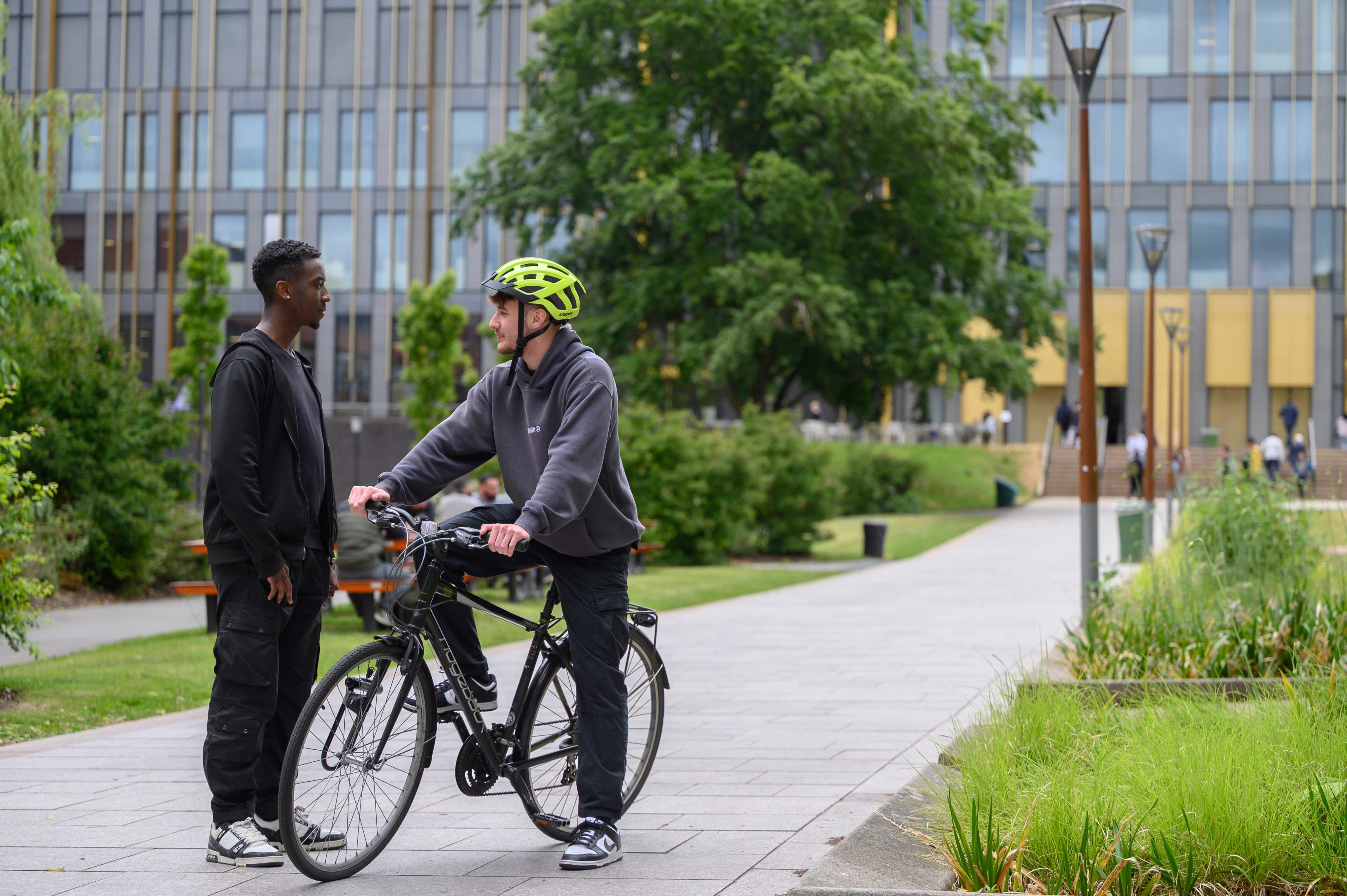 A cyclist talking to a passerby