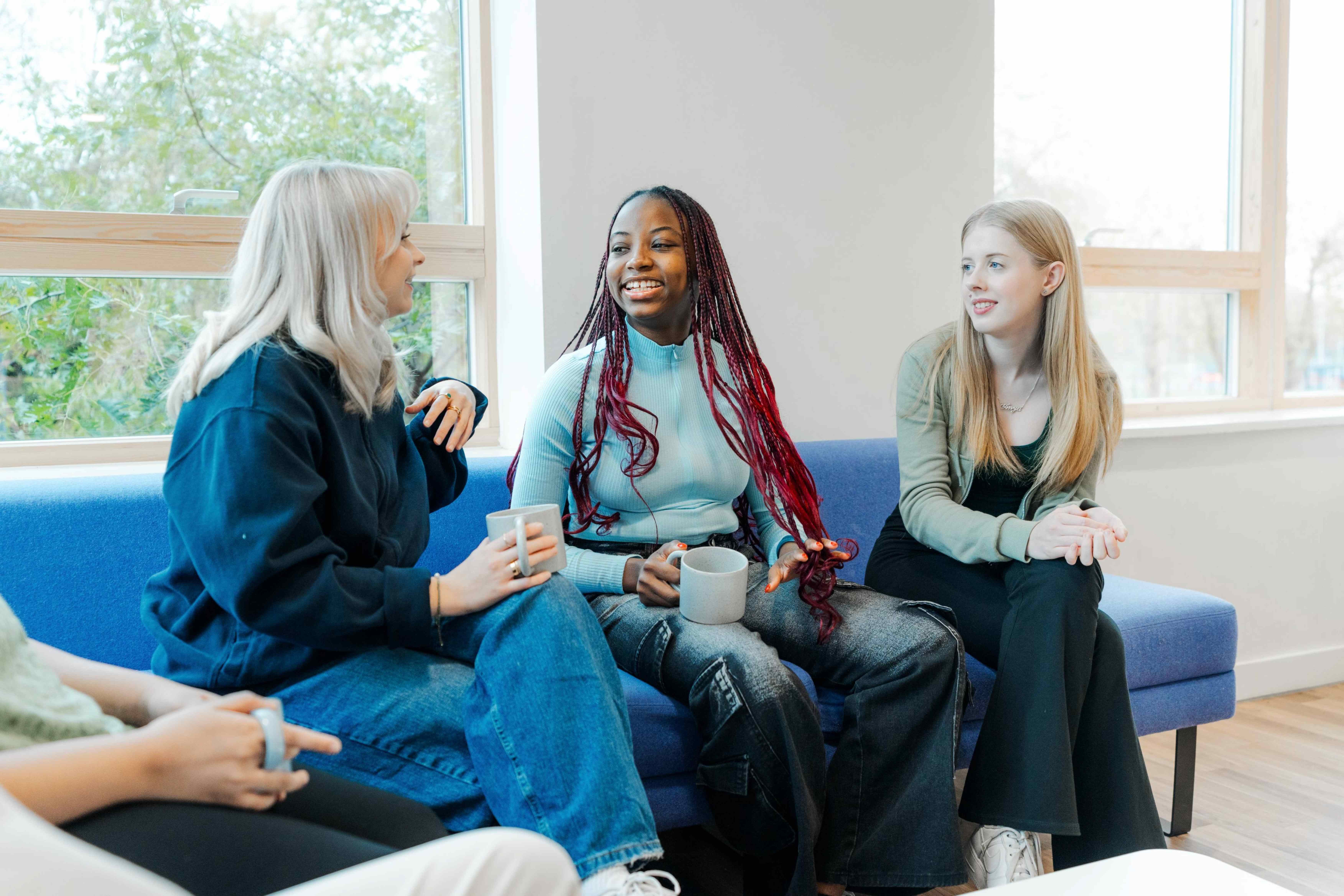 Three female students chatting over coffee