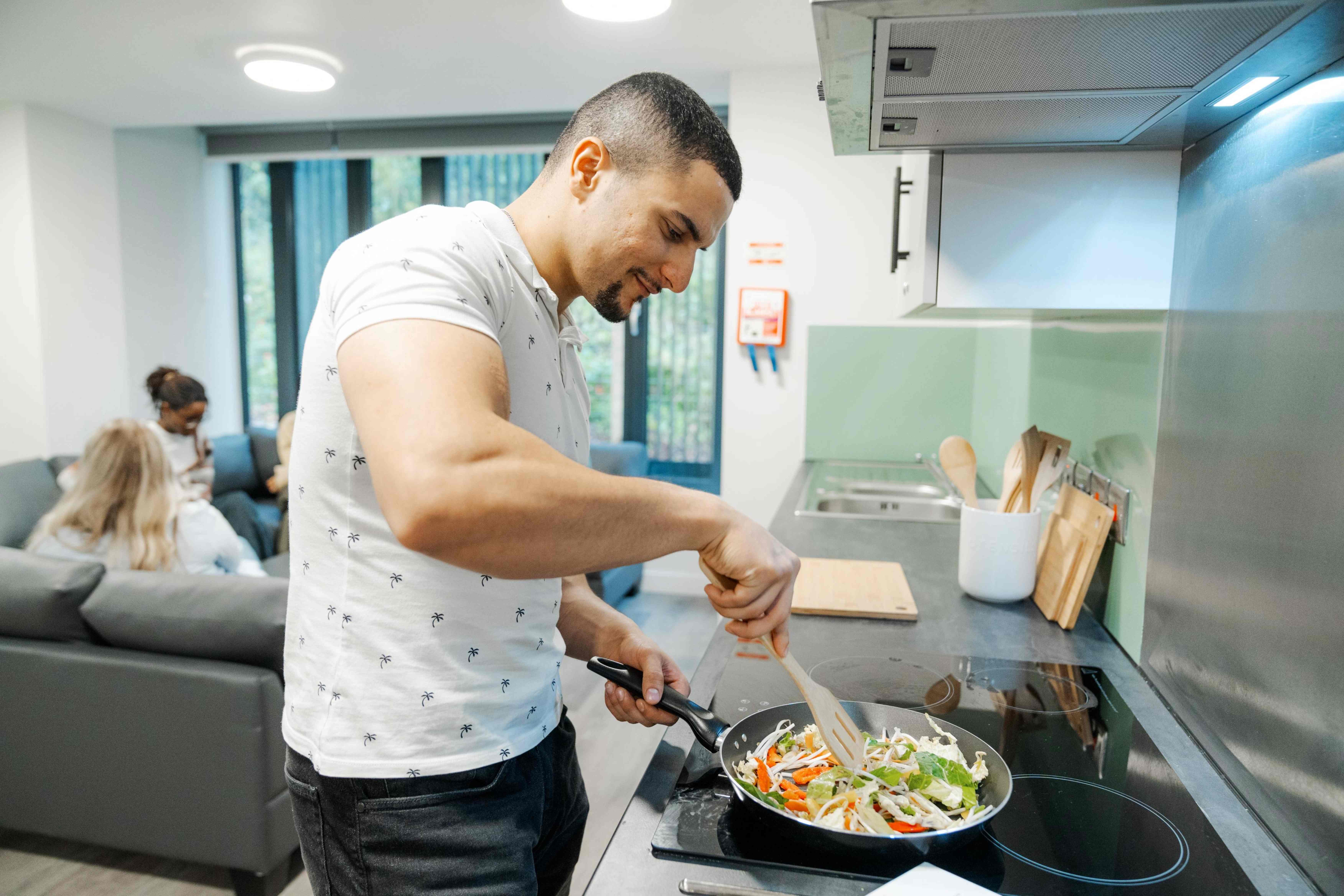 A student cooking a meal in the kitchen