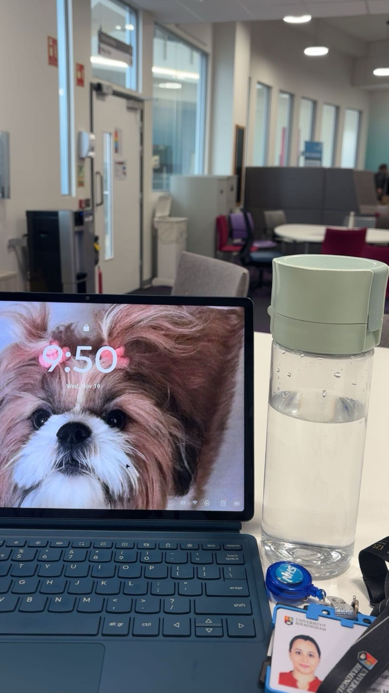 A reusable water bottle on a desk next to an open laptop